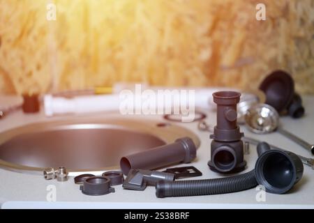 Klempner Werkzeuge und Wasserhahn bereit für die Installation in der Nähe des Waschbeckens auf der Arbeitsplatte in der Küche. Anschlüsse für die Installation des Wasserhahns für den Stockfoto