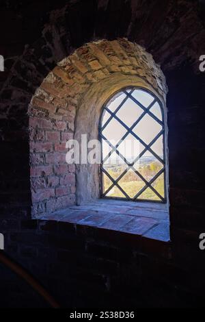 Fenster mit Blick auf die Landschaft in einem alten Backsteinturm Stockfoto
