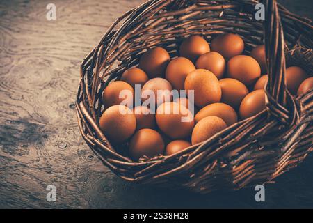 Braune Bio-Eier in einem Korb auf Holztisch Stockfoto
