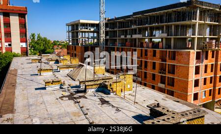 Blick über dem Dach des alten mehrstöckigen Gebäudes, mit Lüftungssystem, Kamin aus Ziegeln, Architektur. Stockfoto