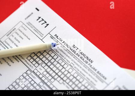 Indonesisches Steuerformular 1771 Körperschaftsteuerpflichtige jährliche Einkommensteuererklärung mit Stift liegt auf der Tabelle des Wirtschaftsprüfers. Indonesisches Steuerformular 1771 Körperschaftsteuerpflichtige Stockfoto