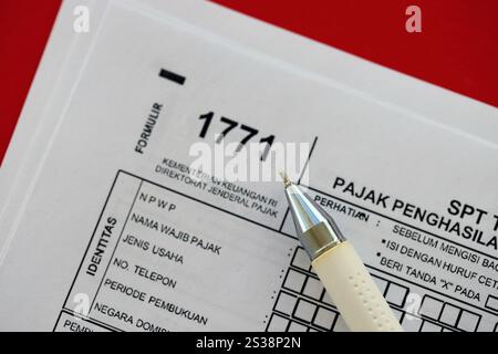 Indonesisches Steuerformular 1771 Körperschaftsteuerpflichtige jährliche Einkommensteuererklärung mit Stift liegt auf der Tabelle des Wirtschaftsprüfers. Indonesisches Steuerformular 1771 Körperschaftsteuerpflichtige Stockfoto