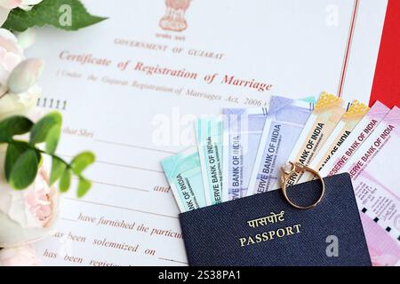 Indische Bescheinigung über die Registrierung der Ehe Blankodokument und Ehering mit Rupiah Geld auf Tisch Nahaufnahme. Indisches Zertifikat von Stockfoto