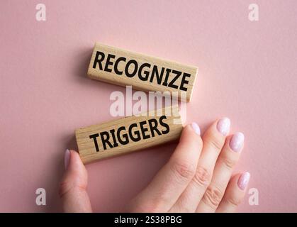 Symbol Auslöser erkennen. Konzeptwörter erkennen Auslöser auf Holzblöcken. Geschäftsmann Hand. Schöner rosafarbener Hintergrund. Business und Anerkennung Trig Stockfoto