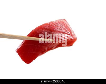 Nahaufnahme eines Stückes köstlicher Thunfisch-Sashimi, gehalten von Essstäbchen, isoliert auf weißem Hintergrund. Frischer Sashimi-Thunfisch auf Essstäbchen gegen weiß Stockfoto