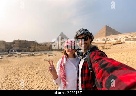 Junges Paar, das ein Selfie vor den Pyramiden von Gizeh, Ägypten, macht Stockfoto