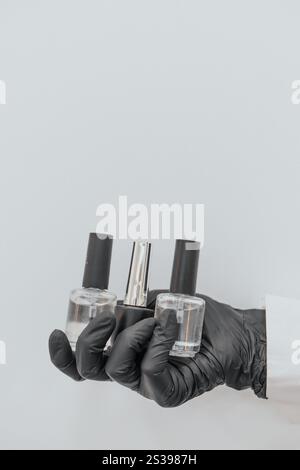 nagellackflaschen mit schwarzen Handschuhen Stockfoto