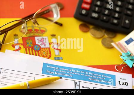 Modelo 130 spanisches Steuerformular für die Einkommensteuer für Arbeitgeber und Berufsangehörige in Direktzahlungen liegt auf der Flagge Spaniens Stockfoto