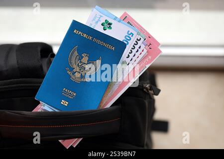 Blue Republic Indonesien Pass mit Geld und Flugtickets auf touristischen Rucksack Nahaufnahme. Tourismus und Reisekonzept. Blaue Republik Indonesien Stockfoto