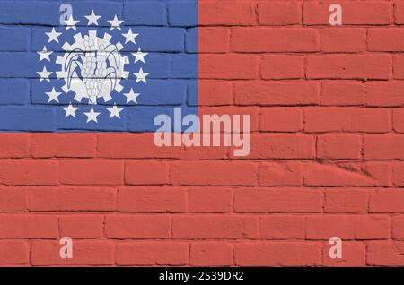 Myanmar-Flagge in Malfarben auf alten Ziegelwänden aus nächster Nähe dargestellt. Strukturiertes Banner auf großem Mauerwerk Hintergrund. Myanmar-Flagge abgebildet in Stockfoto