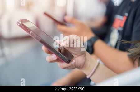 Selektive Fokussierung der Gruppe junger erwachsener Freunde mit Smartphone in der U-Bahn. Mobile Apps im Freien prüfen. Stockfoto