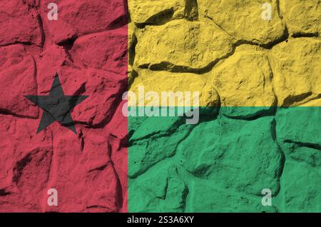 Guinea-Bissau-Flagge in Malfarben auf der alten Steinmauer aus nächster Nähe dargestellt. Strukturiertes Banner auf Steinwand Hintergrund. Guinea-Bissau-Flagge in Farbe dargestellt Stockfoto