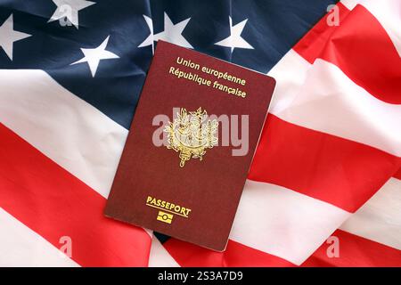 Französischer Pass auf dem Hintergrund der US-Nationalflagge aus nächster Nähe. Tourismus und Diplomatie. Französischer Pass auf US-Flagge Stockfoto