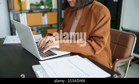 Reifes Geschäft asiatische Unternehmerin im Büro mit Laptop. Geschäftsfrau aus den 60er Jahren mit Technologie asiatische Seniorin. Stockfoto