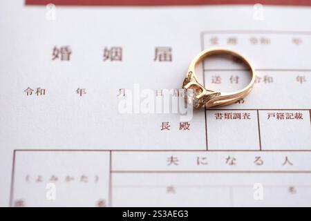 Japanisches Heiratsanzeigeformular, leeres Dokument und Hochzeitsantrag-Ring auf Tisch Nahaufnahme. Japanisches Eheschein leeres Dokument und Stockfoto