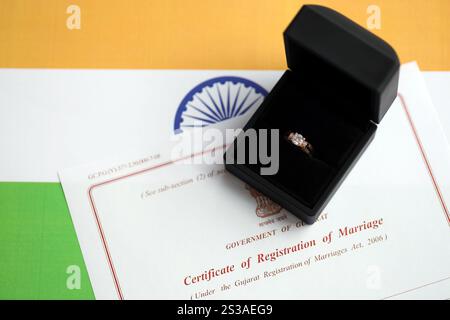 Indische Bescheinigung über die Registrierung der Ehe Blankodokument und Ehering auf Fahne Nahaufnahme. Indische Bescheinigung über die Registrierung der Ehe leer Stockfoto