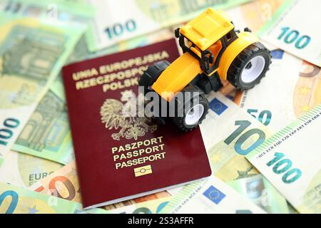 Roter polnischer Pass und gelber Traktor auf Euro-Geldscheinen aus nächster Nähe. Roter polnischer Pass und gelber Traktor auf Euro-Geldscheinen Stockfoto