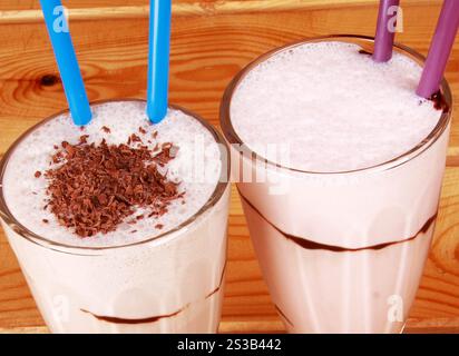 Zwei Cocktails mit Strohhalm auf hölzernem Hintergrund. Zwei Cocktails mit Strohhalm Stockfoto