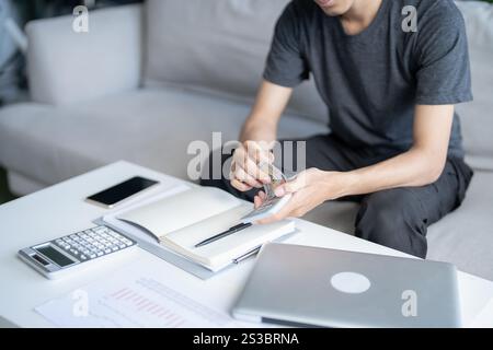Man berechnet Geld Banknoten Finanzen Sparen Wirtschaft Haushalt zahlen Rechnungen Steuern zu Hause finanzieren Stockfoto