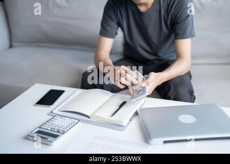 Man berechnet Geld Banknoten Finanzen Sparen Wirtschaft Haushalt zahlen Rechnungen Steuern zu Hause finanzieren Stockfoto