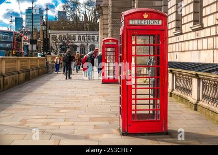 Großartiges Bild von zwei ikonischen roten K6-Telefondosen in der Parliament Street in Richtung Westminster Abbey in London, England. Das traditionelle britische Telefon... Stockfoto