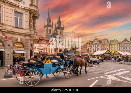 Prag, Tschechische republik - 20. Dezember 2024: Pferdekutsche mit Touristen auf dem Altstadtplatz mit Weihnachtsmarkt zwischen historischen und farbenfrohen Bu Stockfoto