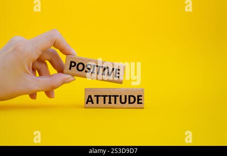 Symbol für positive Einstellung. Konzeptworte positive Einstellung auf Holzklötzen. Schöner gelber Hintergrund. Geschäftsmann Hand. Geschäftliche und positive Attit Stockfoto