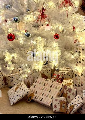 Künstlicher Weihnachtsbaum mit Geschenken darunter. Stockfoto