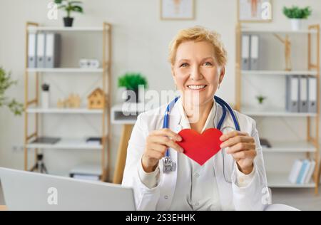 Porträt Eines Leitenden Kardiologen, Der Rotes Herz Im Krankenhaus Hält Stockfoto