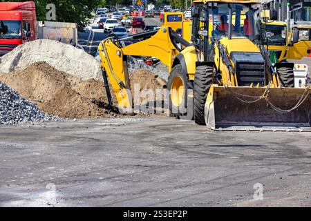 Baumaschinen im Einsatz, die die städtische Landschaft unter starkem Verkehr verändern. Kopierbereich. Stockfoto