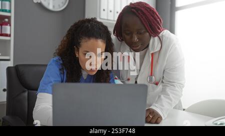 Frauen, die in Gesundheitsbüros mit unterschiedlichem Hintergrund über medizinische Fälle in Innenräumen mit Laptop für effiziente Teamarbeit diskutieren. Stockfoto