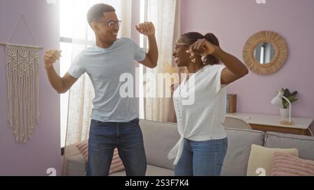 Mutter und Sohn verbringen einen fröhlichen Moment beim Tanzen in ihrem stilvollen Wohnzimmer, in dem sie Liebe und Zweisamkeit im Komfort des eigenen Zuhauses zeigen Stockfoto