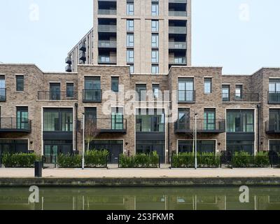 Salford , Manchester, Großbritannien, 01-04-2025: Middlewood Locks. Modernes Backsteingebäude an einem ruhigen Kanal unter klarem Himmel. Stockfoto