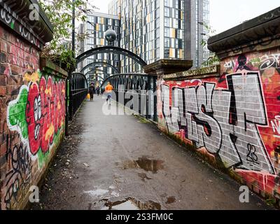 Manchester, UK, 01-04-2025: Urban Street Art mit farbenfrohen Graffiti auf einem Stadtbrückensteg. Stockfoto