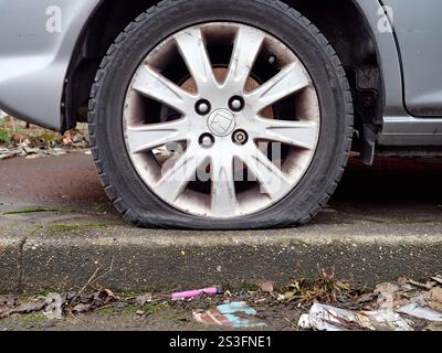 Salford, Manchester, Großbritannien, 01-04-2025: Reifenpannen auf einem Auto, das auf einem übersäten Straßenrand geparkt ist. Stockfoto