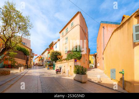 Farbenfrohe Geschäfte und Cafés säumen die engen, hügeligen Gassen und Straßen der Altstadt von Saint-Tropez, Frankreich, entlang der Cote d'Azur französischen Riviera. Stockfoto