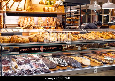 Eine Schaufensterbox mit Brot, Desserts, Trockenfleisch und Gebäck in einer Gourmet-Wurst- und Bäckerei in Sevilla, Spanien. Stockfoto