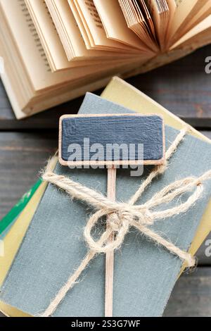 Stapel Bücher und leeres Tafellabel. Stockfoto