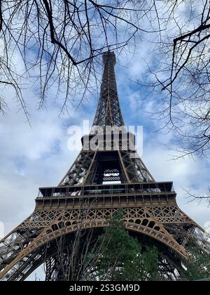 Einzigartige Perspektive auf den Eiffelturm mit üppigem Grün an einem teilweise bewölkten Tag Stockfoto