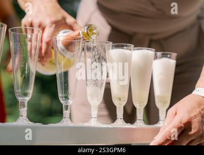 Ein Mädchen, das Champagner in Gläser gießt. Hochwertige Fotos Stockfoto