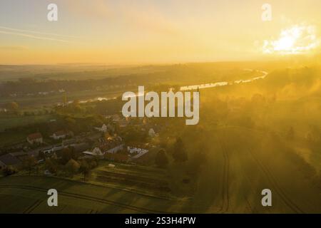 Luftaufnahme, Blick auf das Dorf mit der Michaeliskirche bei Sonnenaufgang wirft die Kirche einen langen Schatten, die Elbe im Hintergrund, Zehren, Sachsen, Deutschland Stockfoto