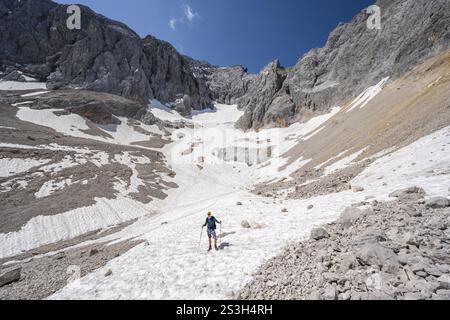 Bergsteiger auf einem Schneefeld, Bergbecken mit Gletscherresten des Hoellentalferners, Hoellental, felsige Berggipfel, Hoellental, Bayern, Deutsch Stockfoto