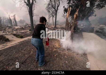 Altadena, Usa. Januar 2025. Ein Bewohner von Altadena löscht einen brennenden Baum aus. Das Eaton Firere in Altadena hat die Evakuierung von mehr als 1000 000 Einwohnern und bestätigte, dass fünf Menschen das Leben genommen wurden. Das Feuer, das von den Winden von santa ana angetrieben wird, liegt derzeit auf 000 Hektar mit 0 % Eindämmung. (Foto: Jon Putman/SOPA Images/SIPA USA) Credit: SIPA USA/Alamy Live News Stockfoto