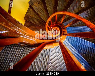 Eine markante Wendeltreppe in der Tower Bridge, London, bietet lebendige Farben, komplizierte Kurven und historischen Charme. bietet eine einzigartige Architektur Stockfoto