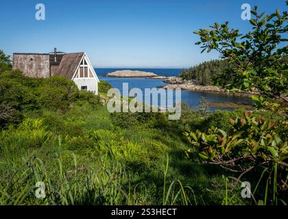 Ruhige Szene aus Duncan's Cove, Nova Scotia, Kanada, mit einer rustikalen Hütte eingebettet in Grün mit atemberaubendem Blick auf die Küste des Atlantischen Ozeans Stockfoto