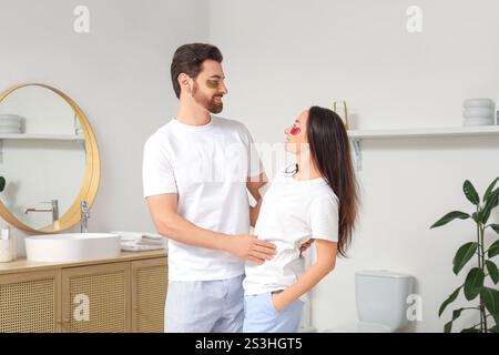 Liebevolles Paar mit Flecken unter den Augen, die sich im Badezimmer umarmen Stockfoto