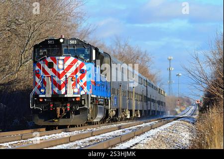 Bartlett, Illinois, USA. Ein Metra-Pendlerzug in westlicher Richtung, der von Chicago ausgeht und sich dem örtlichen Pendlerbahnhof nähert. Stockfoto