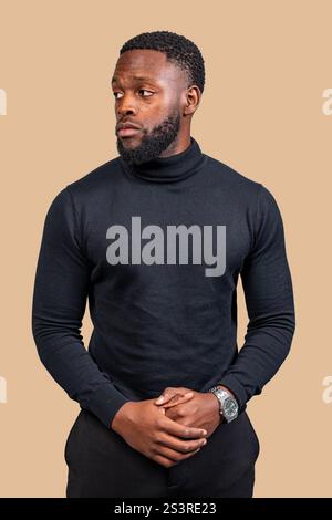 Studio-Porträt eines ernsthaften jungen Geschäftsmannes, der wegschaut, einen schwarzen Rollkragenkragen und eine Armbanduhr trägt Stockfoto