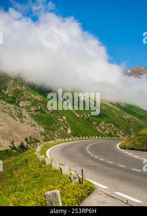 Panoramablick auf die Kurve einer kurvenreichen Straße in der Großglockner Hochalpenstraße, Österreich. Die Strecke liegt zwischen hochalpinen Bergen, die mit grünem Vegetati bedeckt sind Stockfoto