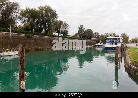 PESCHIERA DEL GARDA, ITALIEN - 22. OKTOBER 2024: Ein Blick auf einen Kanal oder das Ufer des Gardasees in Peschiera del Garda, Italien, mit Booten, die entlang der Stockfoto